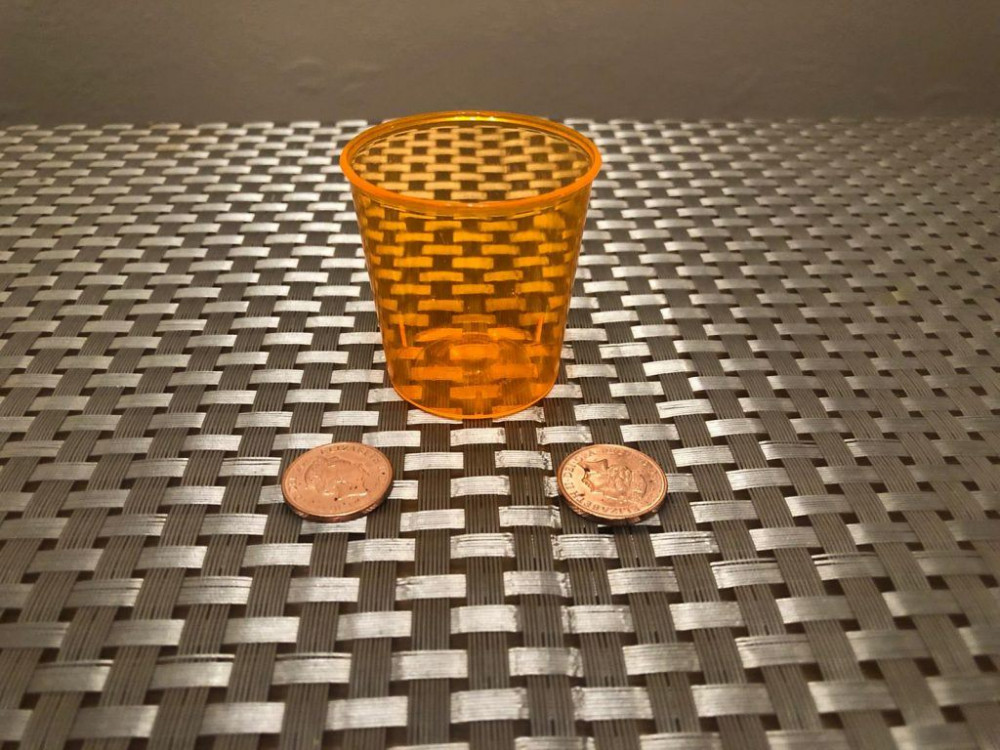 Shot glass and two coins