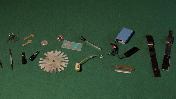 tools used to cheat at casino slot games laid out on a green background